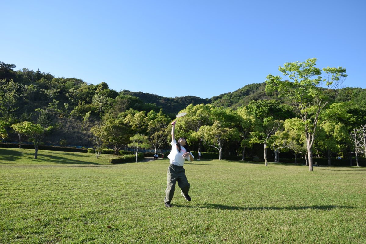 芝生でバトミントンする子ども