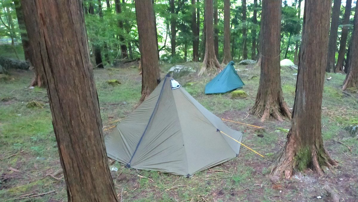 森の中にワンポールテントが設営されている。