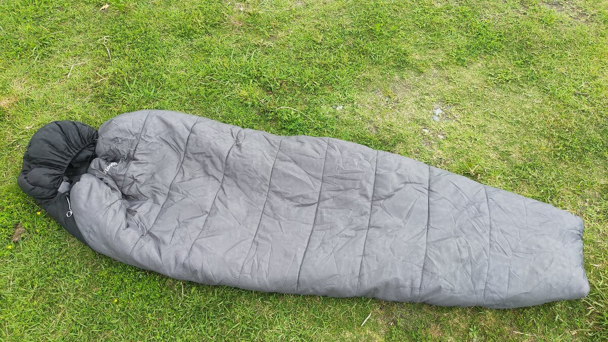マミー型の寝袋が芝の上に置かれている。
