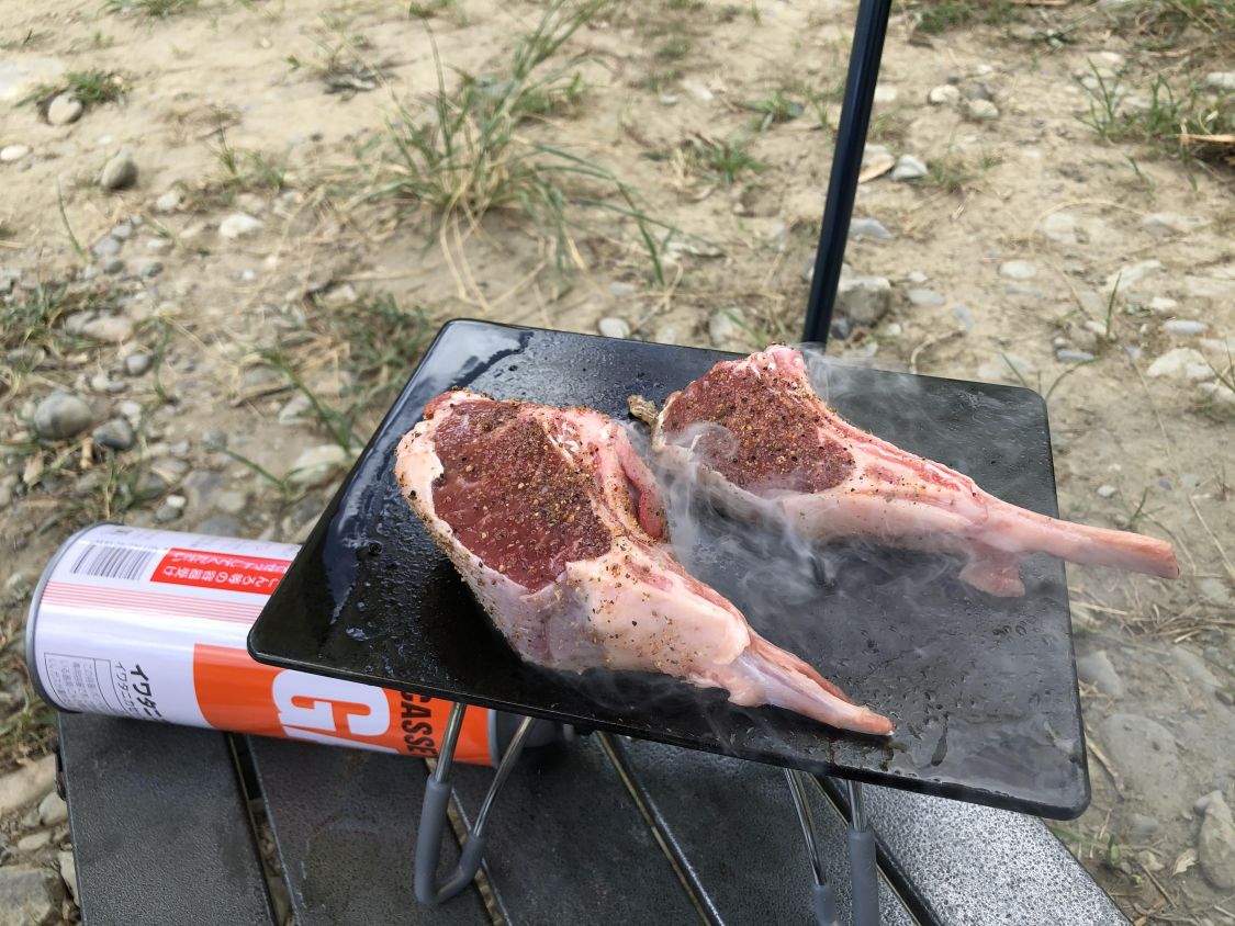 屋外でラムチョップを焼く様子