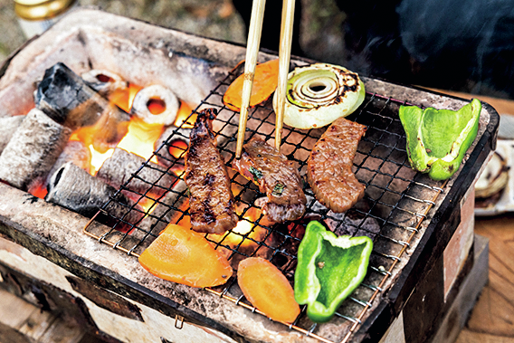 七輪で肉や野菜を焼く様子