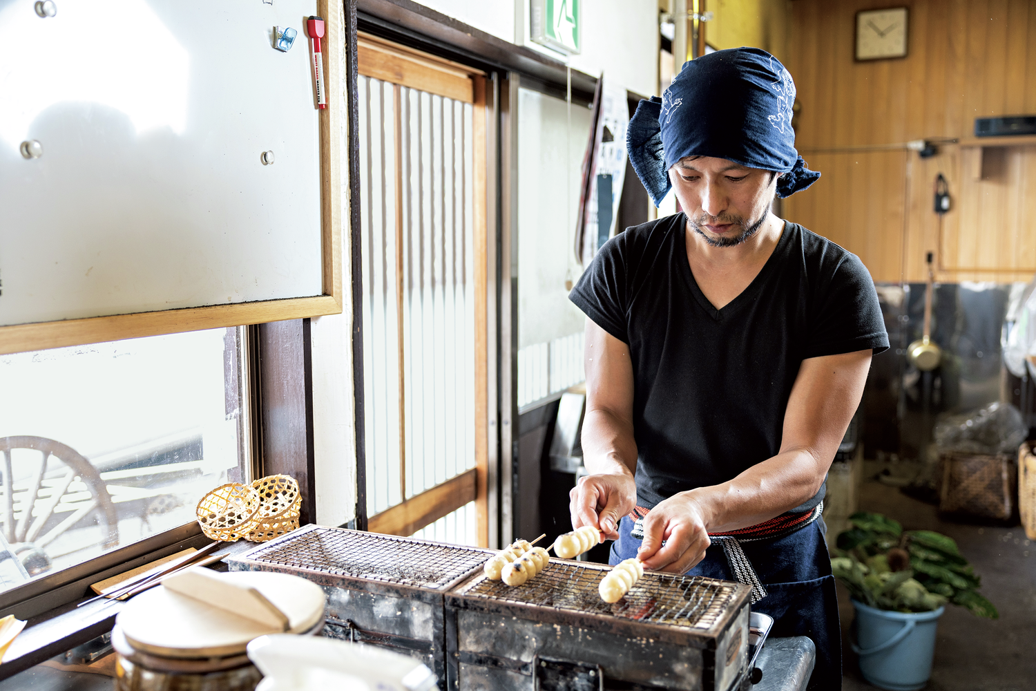 七輪で団子を焼く男性