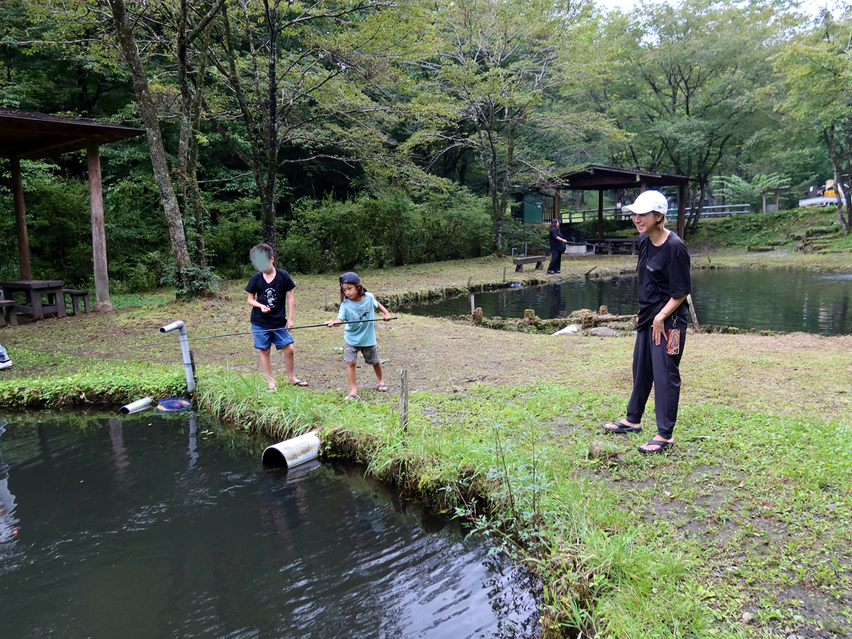 池で釣り糸を垂らす親子