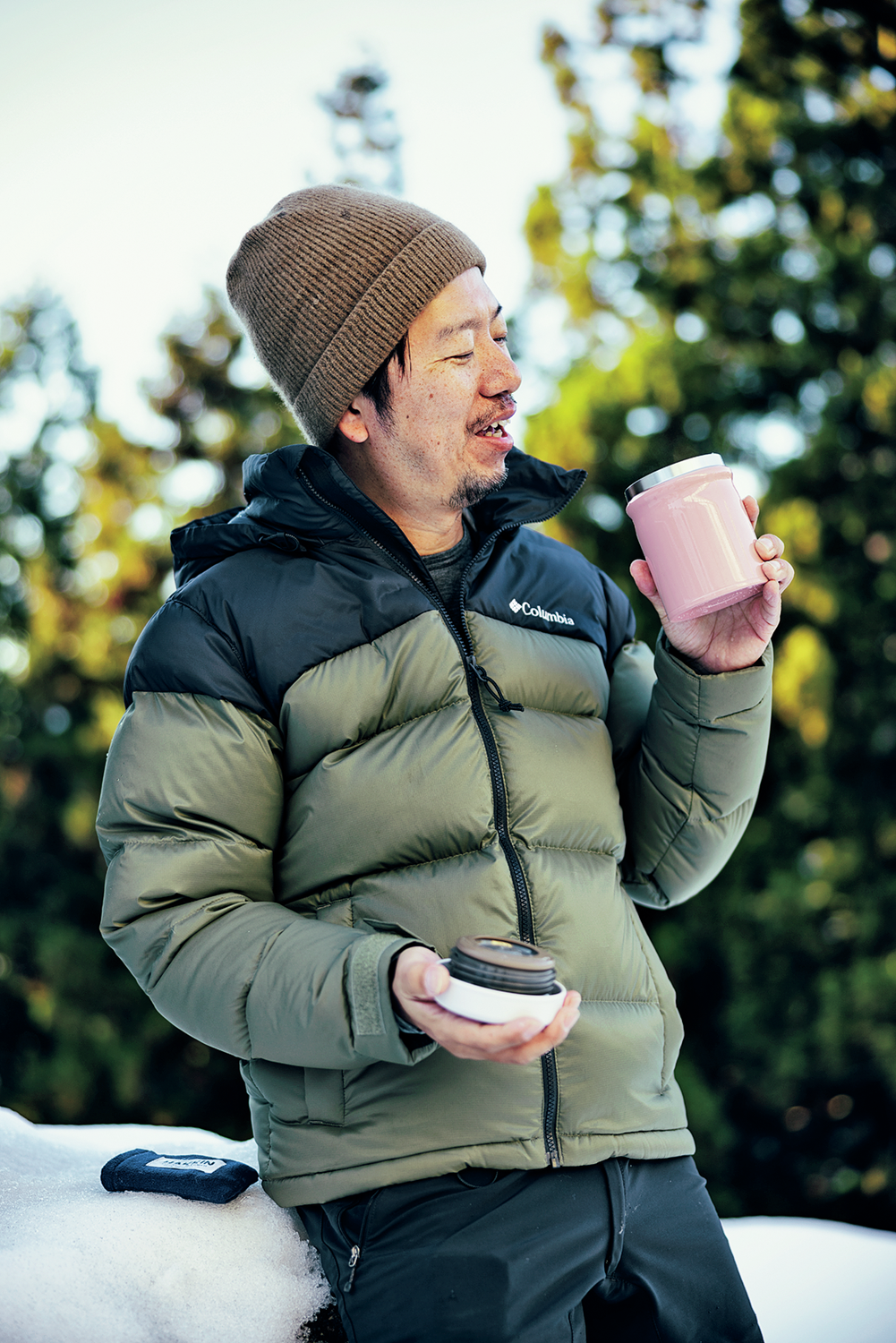 ダウンジャケットを着てスープを飲む男性