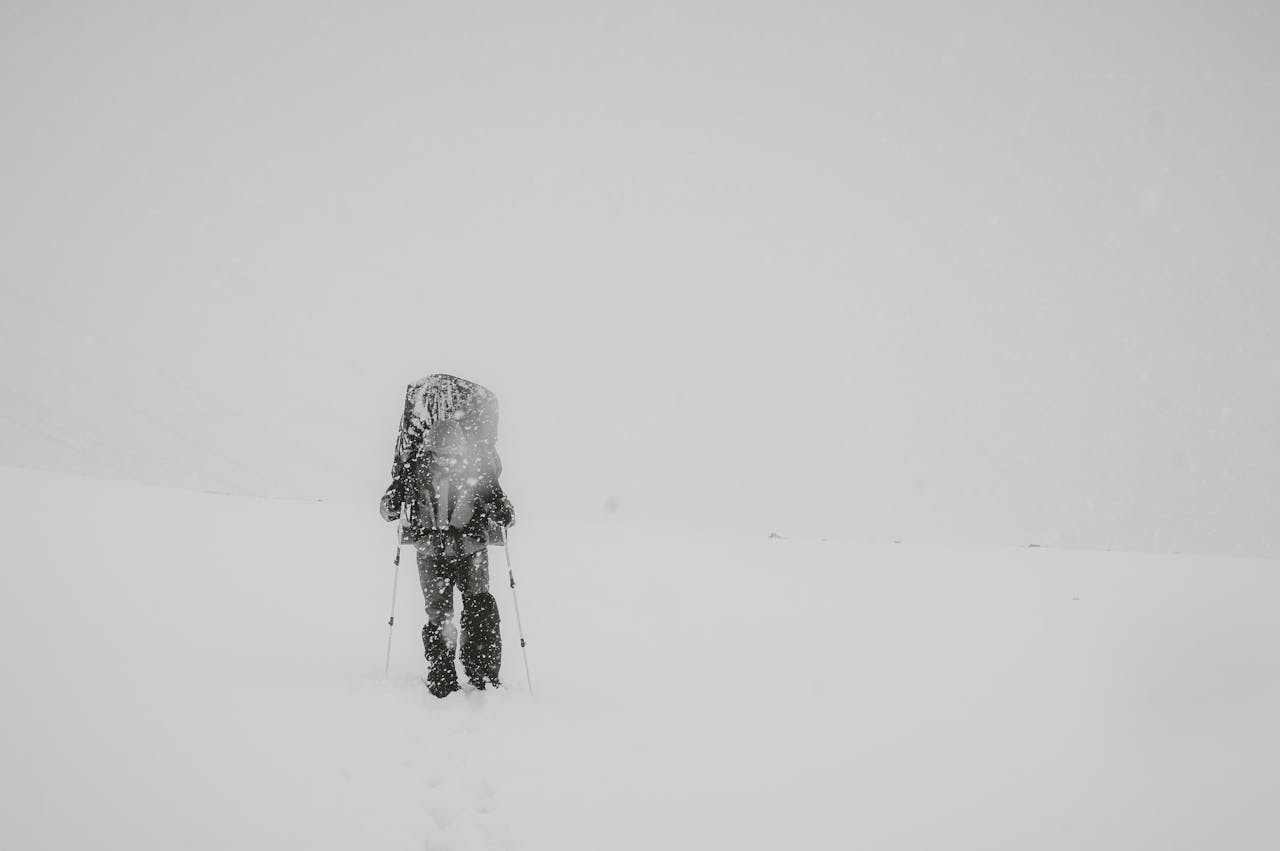 雪の中登山をする人物