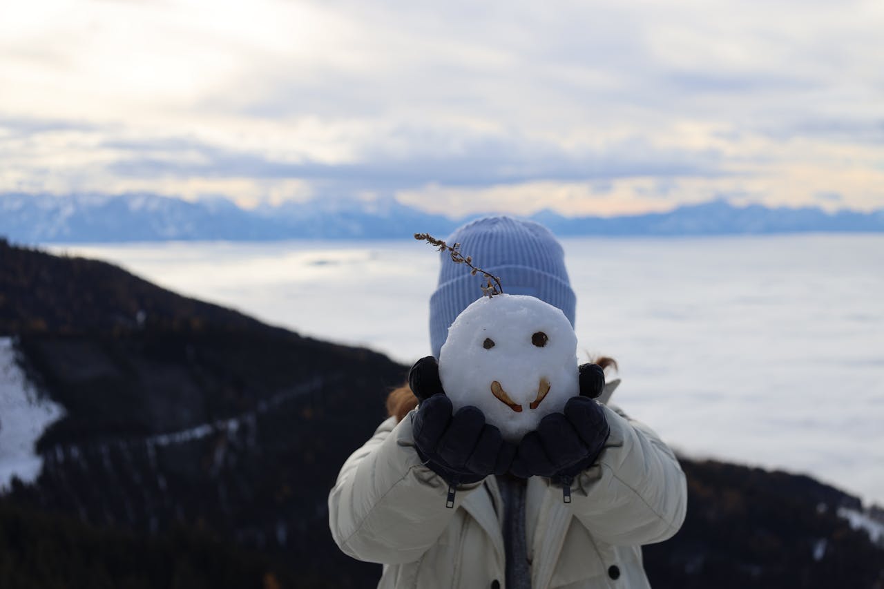 顔のついた雪玉を持つ子供