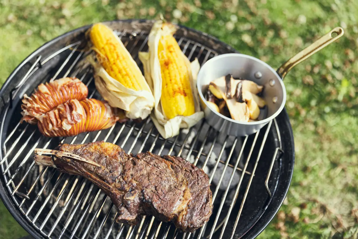 肉やトウモロコシをグリルで焼く様子