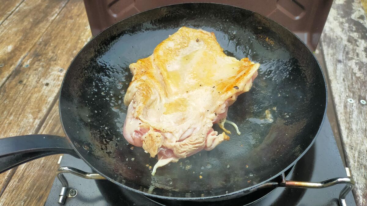 鉄フライパンで肉を焼いている様子。