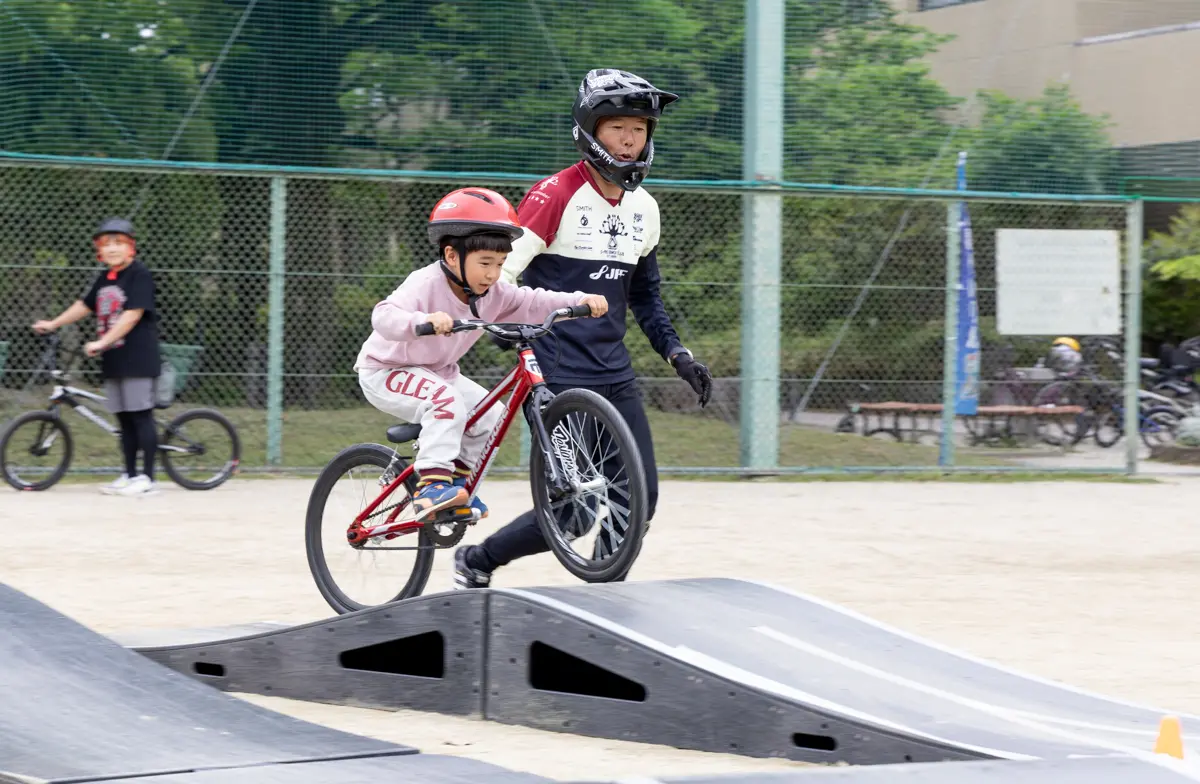 障害物を自転車で乗り越える子ども